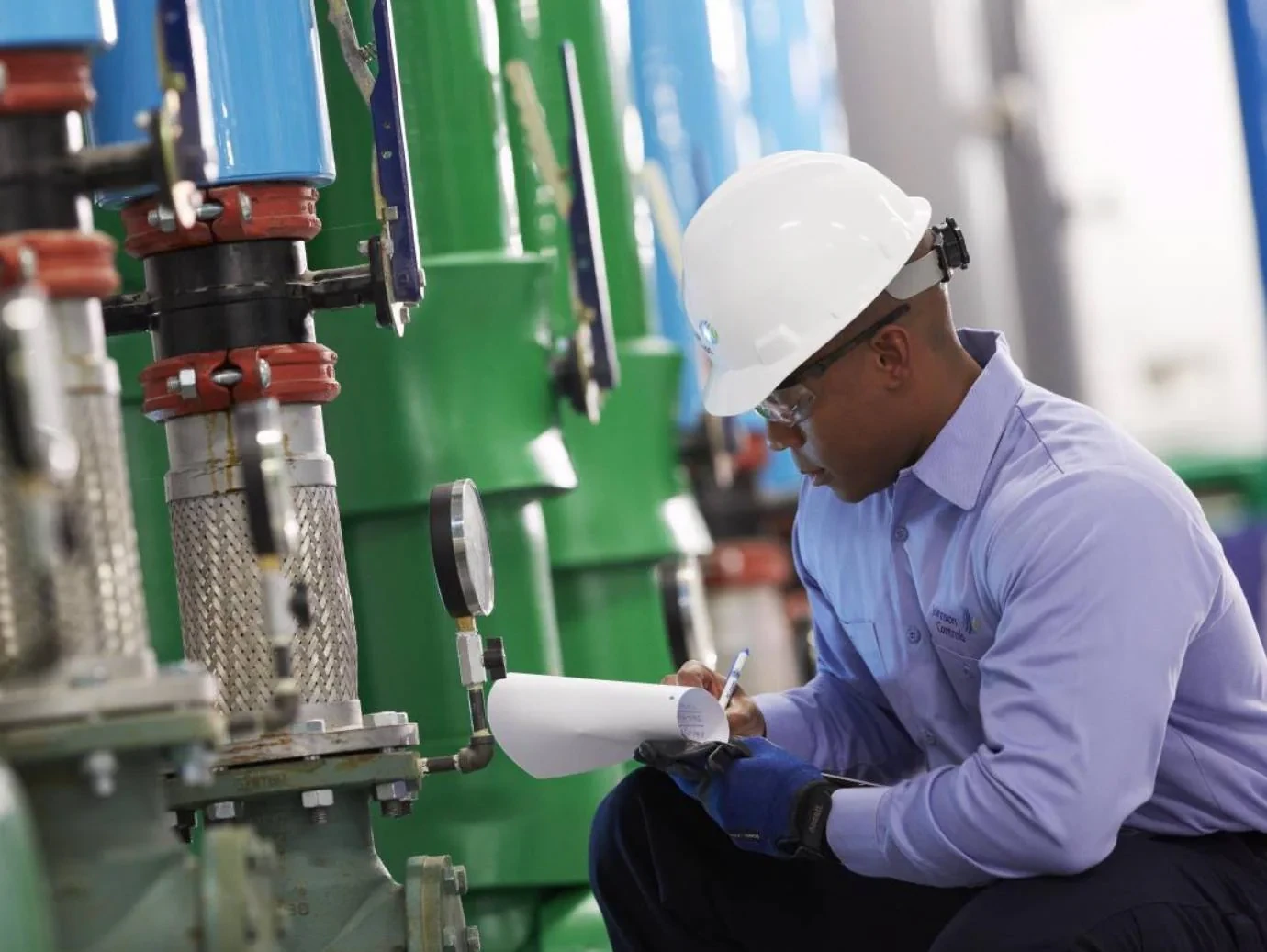 HVAC technician recording equipment readings during a mechanical system inspection